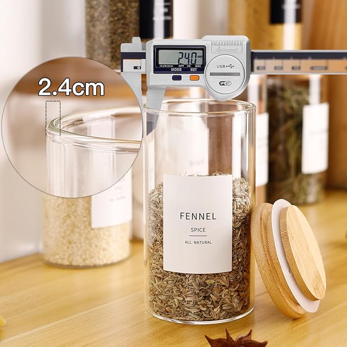 Glass spice jar with digital thermometer and fennel spice inside, on a wooden surface.