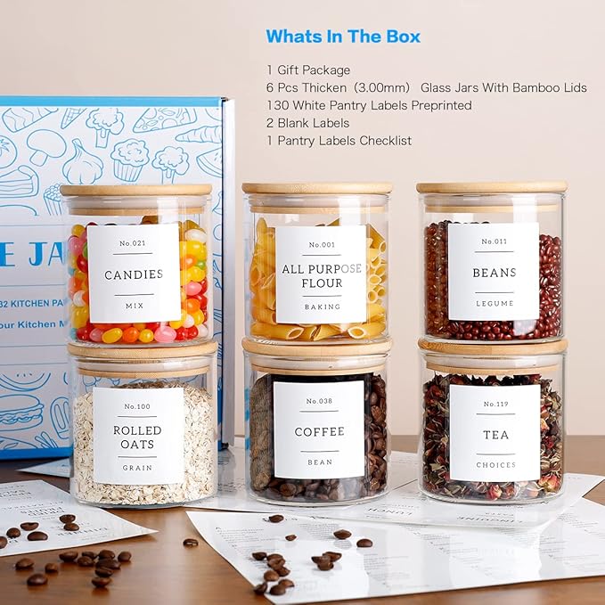 Set of glass jars with labels containing various pantry items on a table.