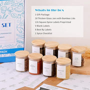 Set of glass jars with wooden lids on a table with labels and a box in the background.