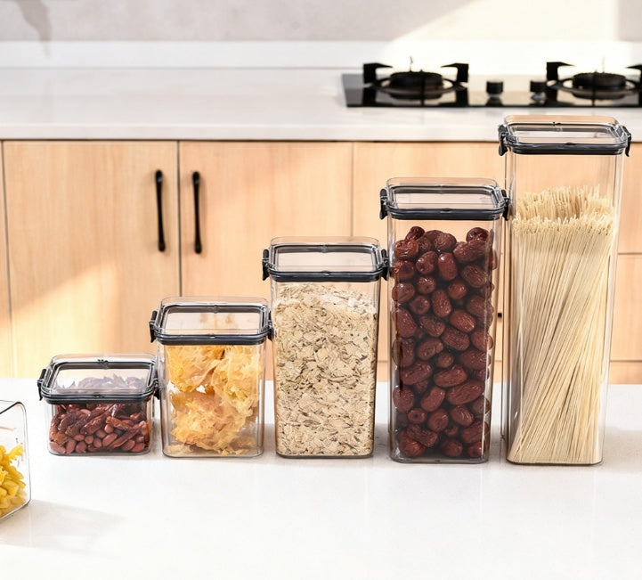 Set of clear kitchen storage containers with food on a countertop