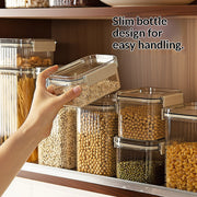 Hand holding a clear food storage container with text 'Slim bottle design for easy handling' in a kitchen setting.