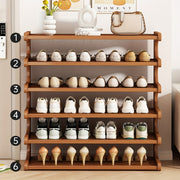 Wooden shoe rack with various shoes on shelves in a room setting.