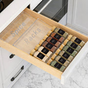 Open kitchen drawer with spice racks labeled 'Spice Racks' on a marble countertop.