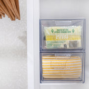 Clear plastic container with yellow washcloths and sponges on a white background